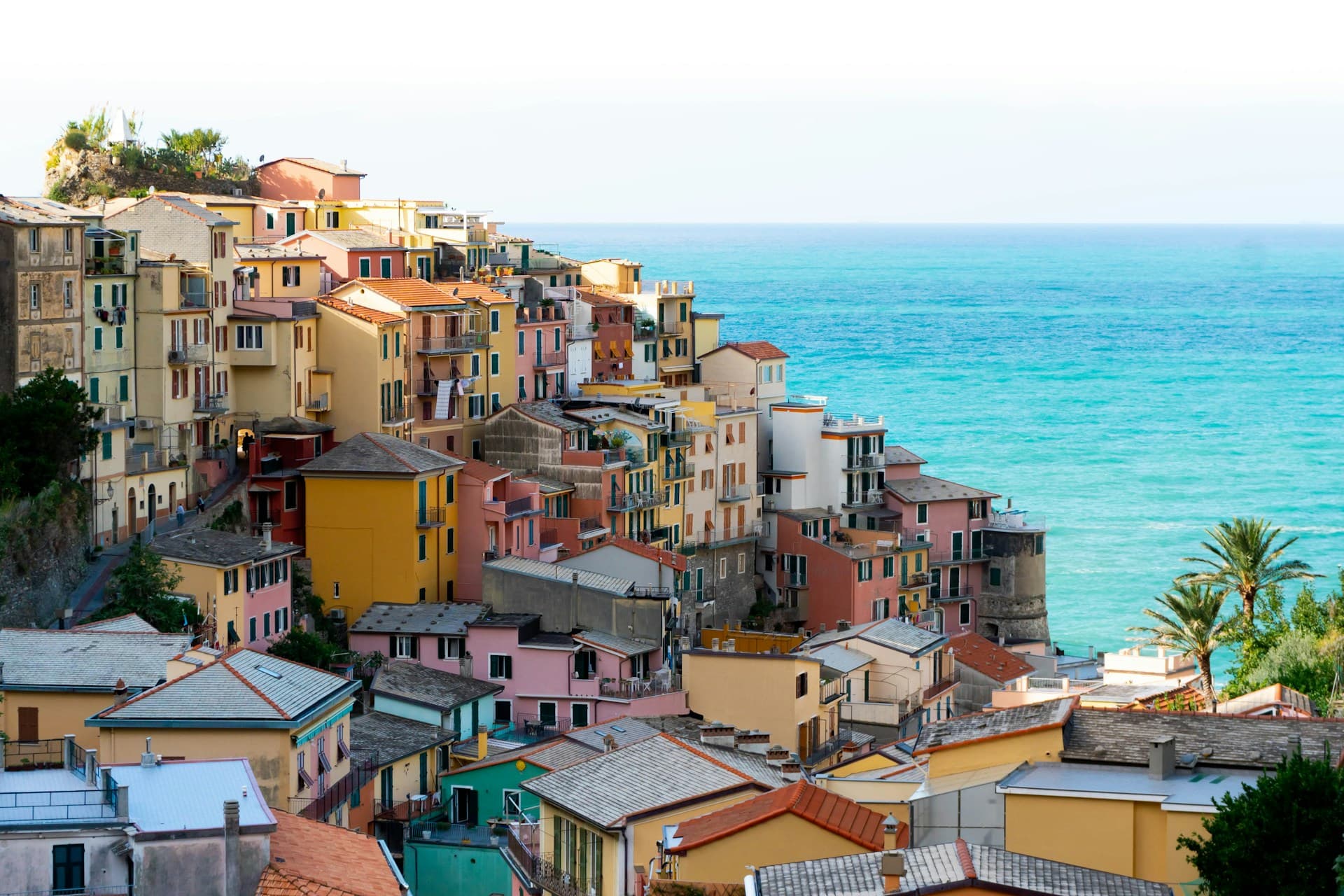 The best time to visit Cinque Terre Italy is during spring and autumn, specifically the months of April, May, September and October. View of one of the Cinque Terre in Italy with the sea in the distance