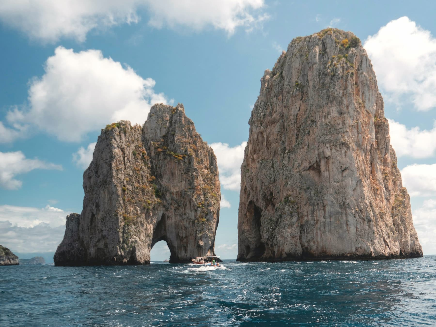View of the Faraglioni rock formations from the water in Capri
