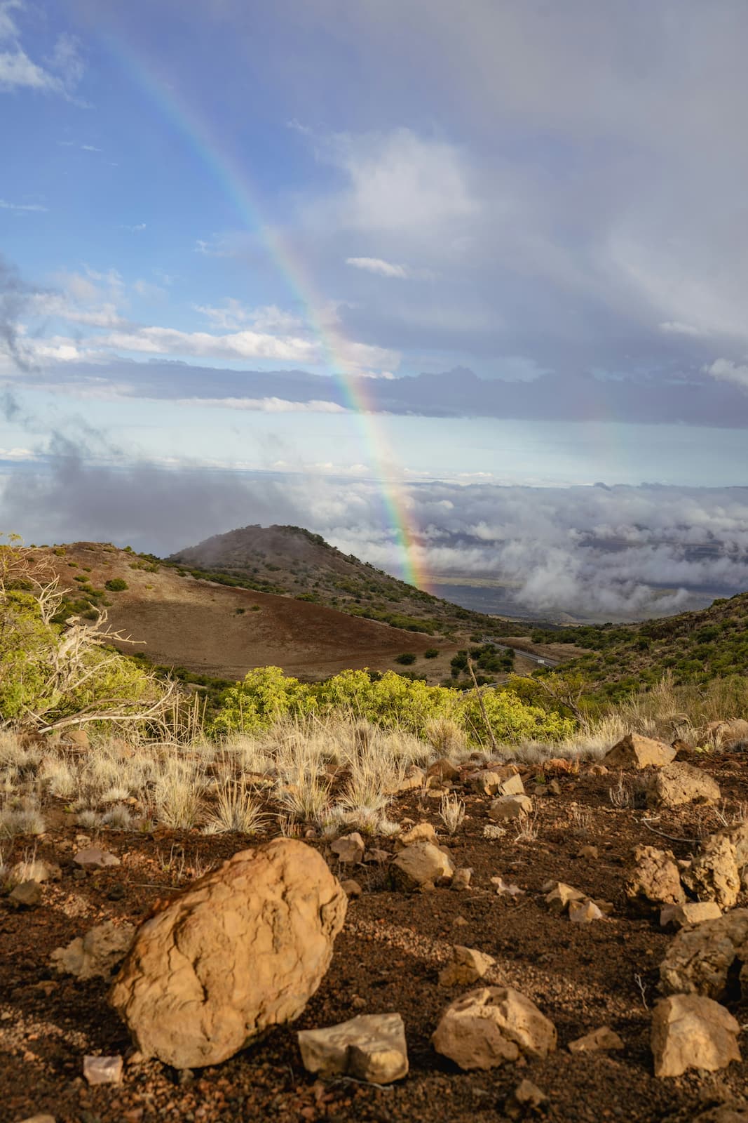 How do you decide where to go in Hawaii on  The Big Island? There is an incredible array of diverse landscapes to be enjoyed on the Island of Hawaii. View of a rainbow over a mountain range on the Island of Hawaii
