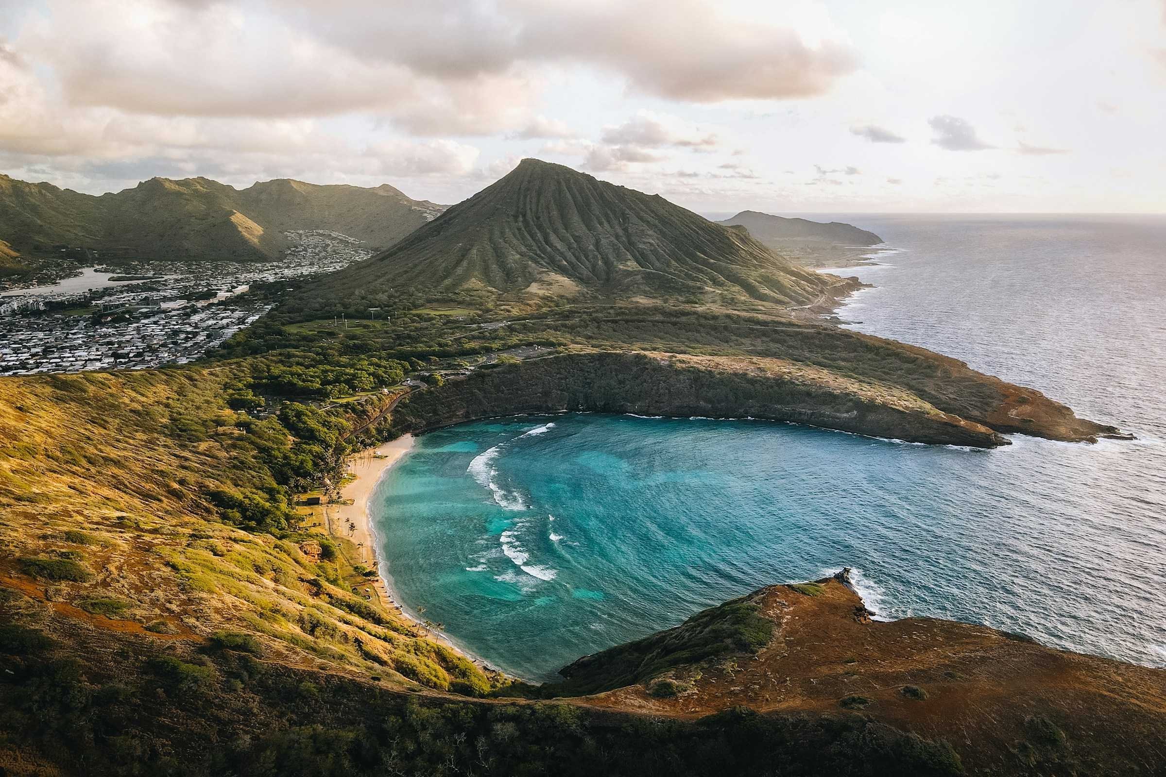 Oahu is a Hawaiian island with a bit of everything. If you're trying to find the best Hawaiian island for your vacation, Oahu may just be the option for you. It's great for first-timers and families. An aerial view of a beach and mountain on the Hawaiian island of Oahu