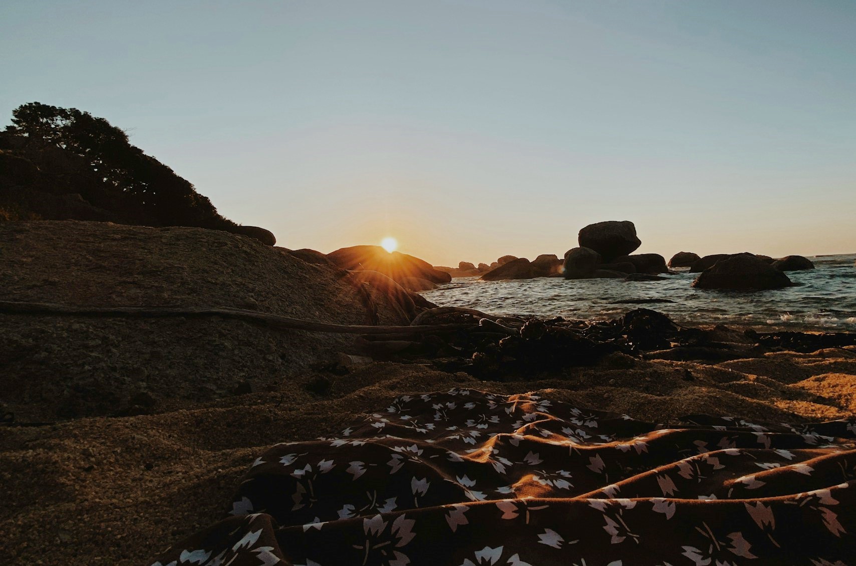 View of the sun setting over the rocks on Oudekraal Beach, Cape Town