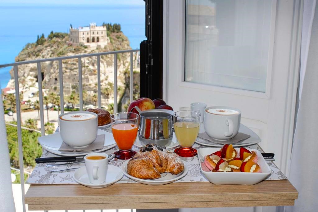 View of the Santuario di Santa Maria in the background with breakfast in the foreground at the B&B Island Vista Mare in Tropea